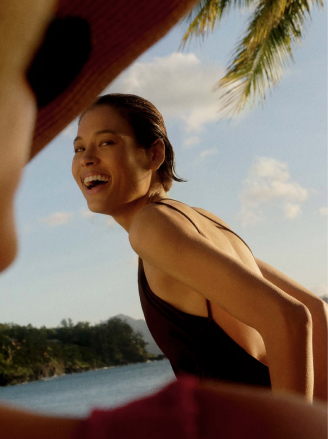 A woman laughing during a seaside workout