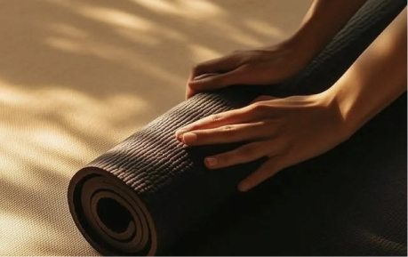 Hands rolling up a yoga mat