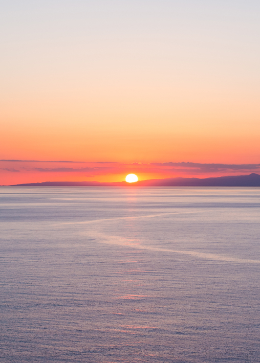 The sun setting over the sea