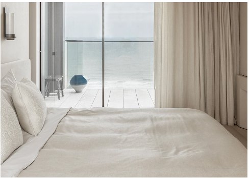 A bedroom opening onto a sea-facing terrace